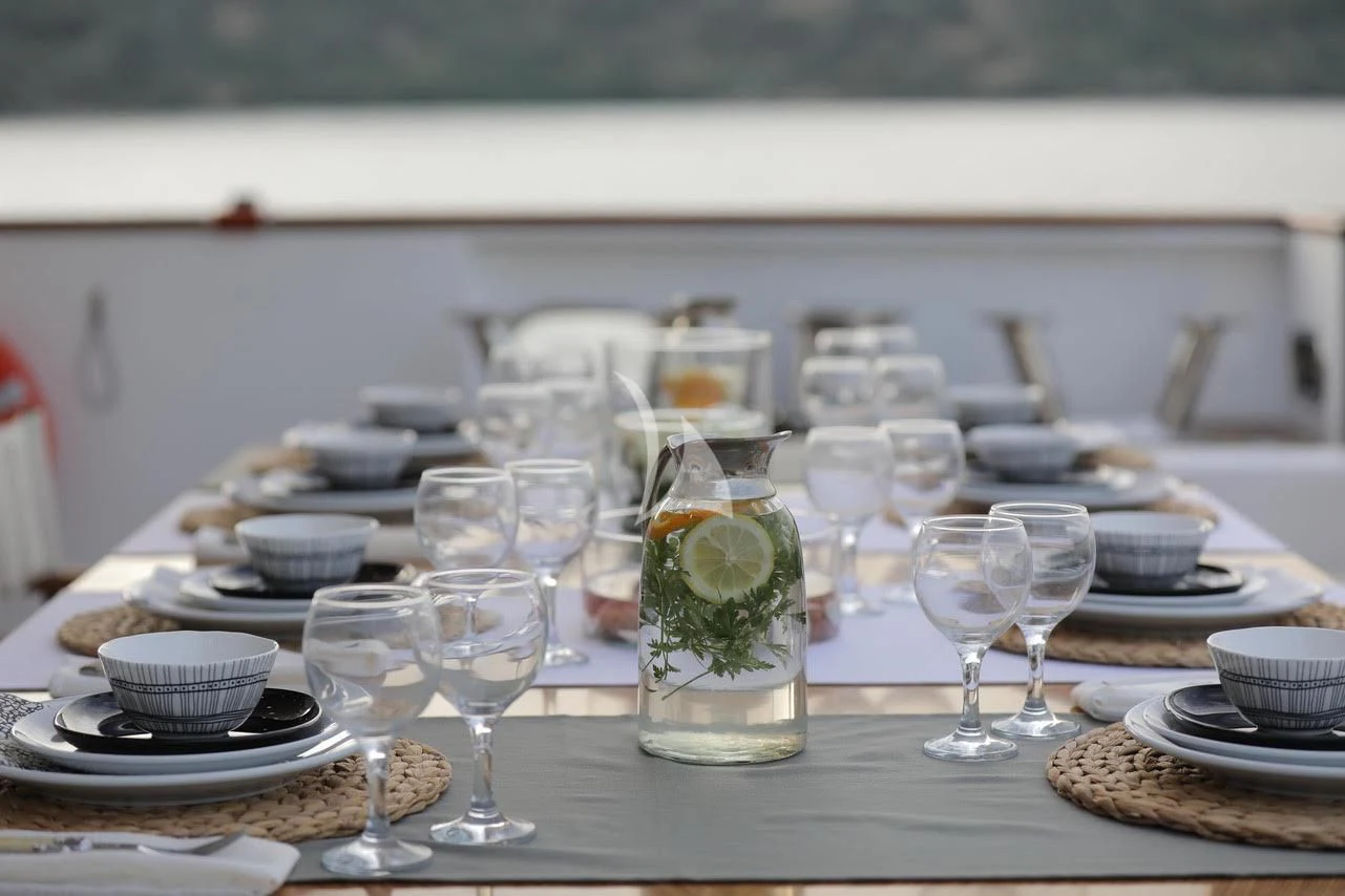 a table with plates and glasses aboard OTTAWA IV Yacht for Sale