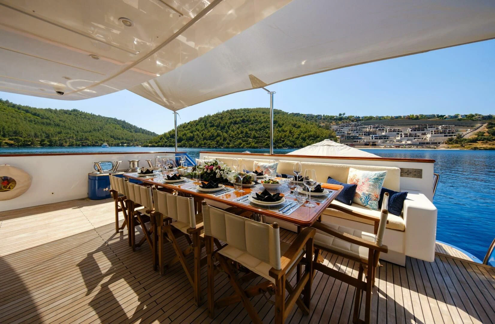 a table set for a meal on a deck overlooking a body of water aboard OTTAWA IV Yacht for Sale