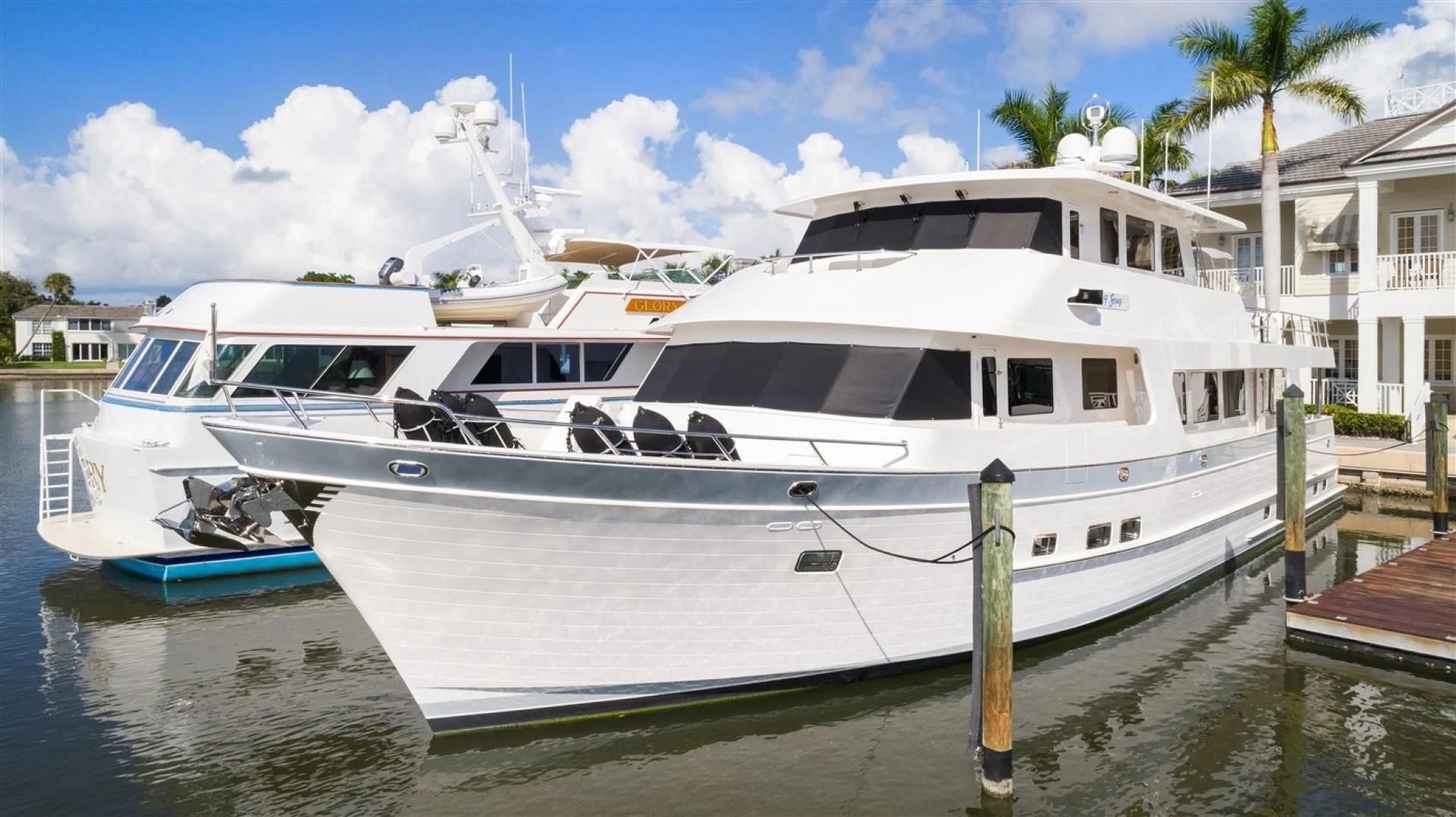 a white yacht docked at a dock aboard BLUE CHIP Yacht for Sale