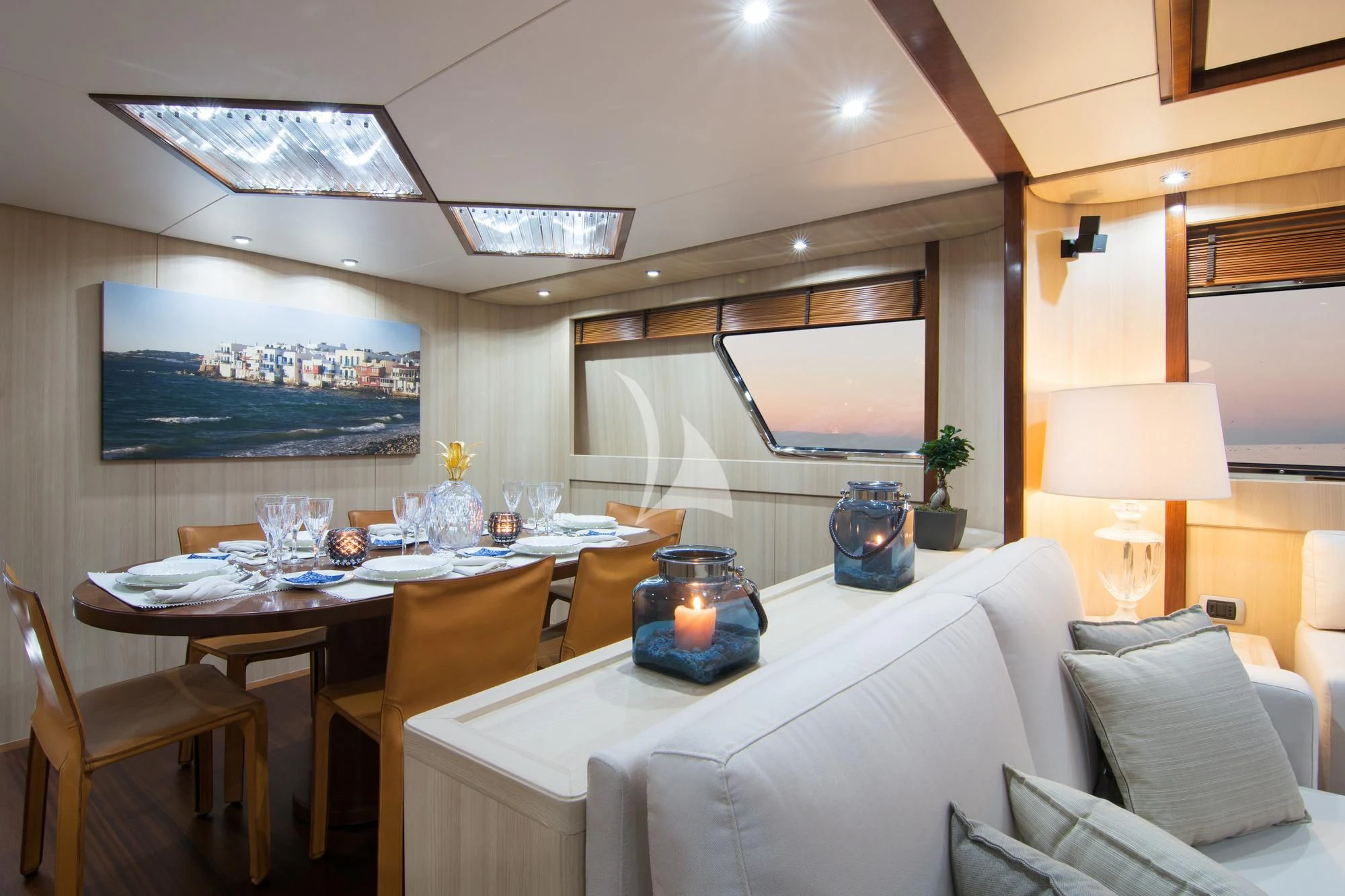 a living room with a white couch and a large television screen aboard ACIONNA Yacht for Sale