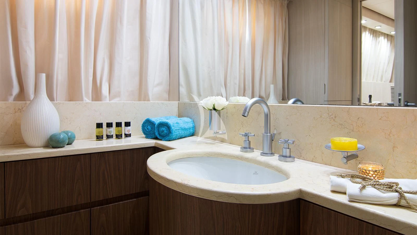 a bathroom with a sink and a vase of flowers aboard ACIONNA Yacht for Sale