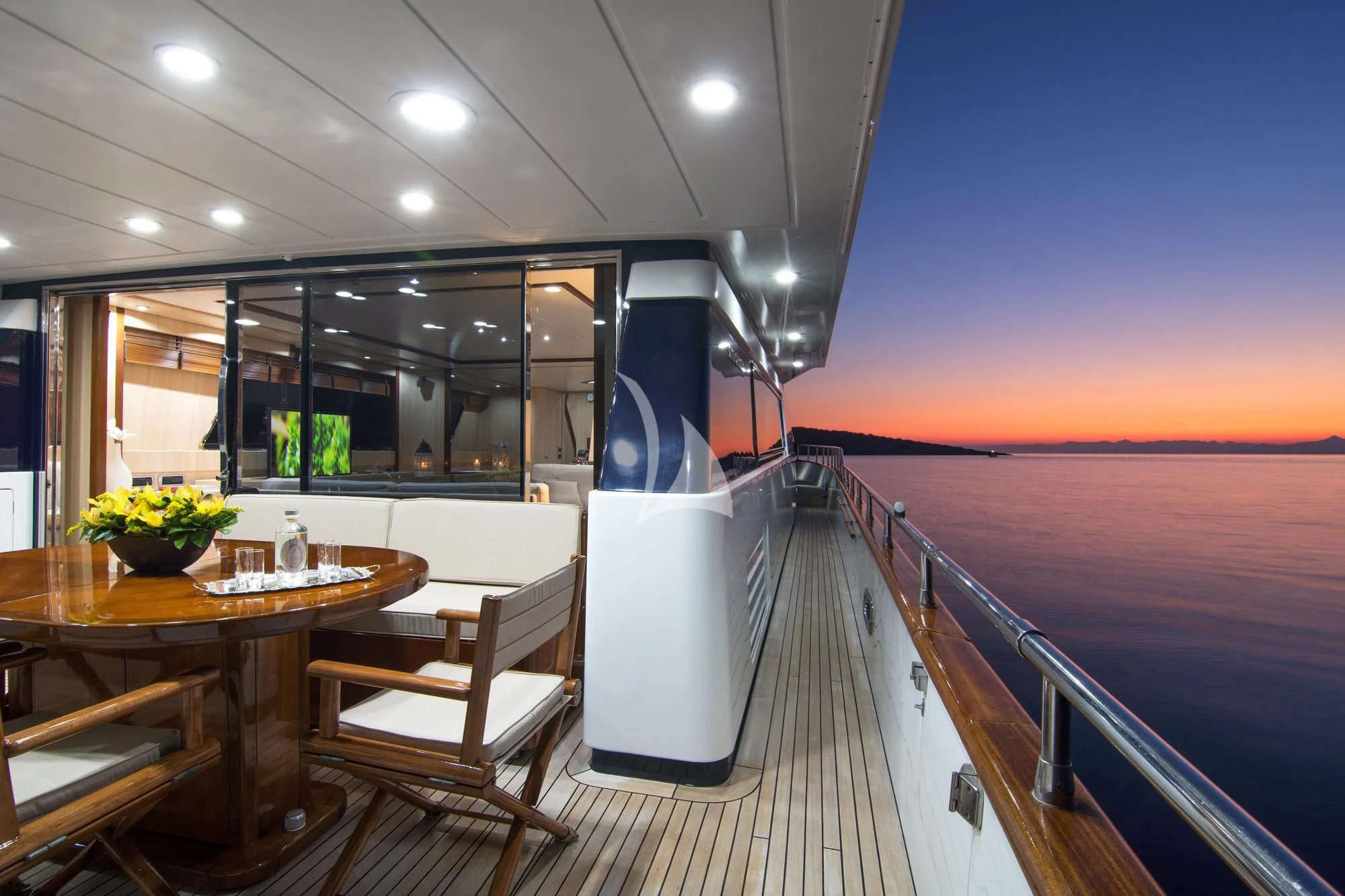 a deck with a table and chairs aboard ACIONNA Yacht for Sale