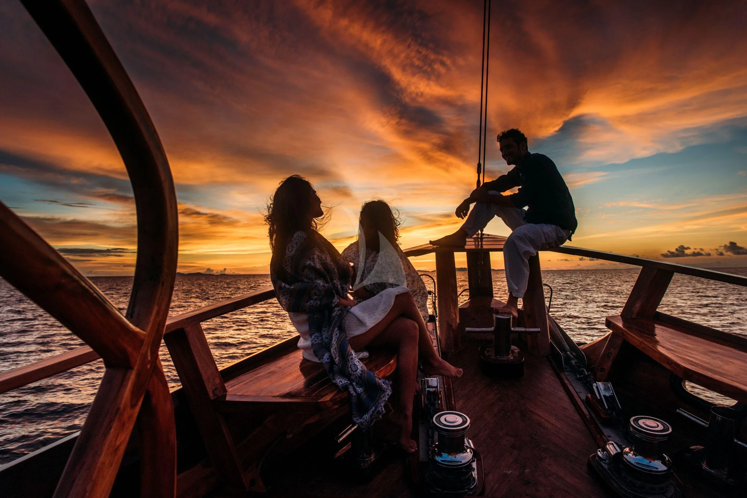 a group of people sitting on a boat with a sunset in the background aboard SEQUOIA Yacht for Sale