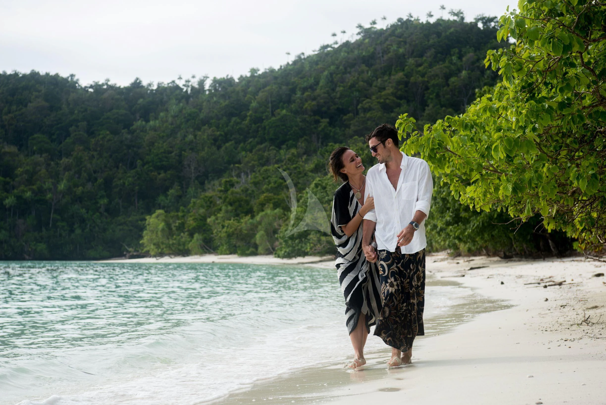 a man and woman standing on a beach with trees in the background aboard SEQUOIA Yacht for Sale