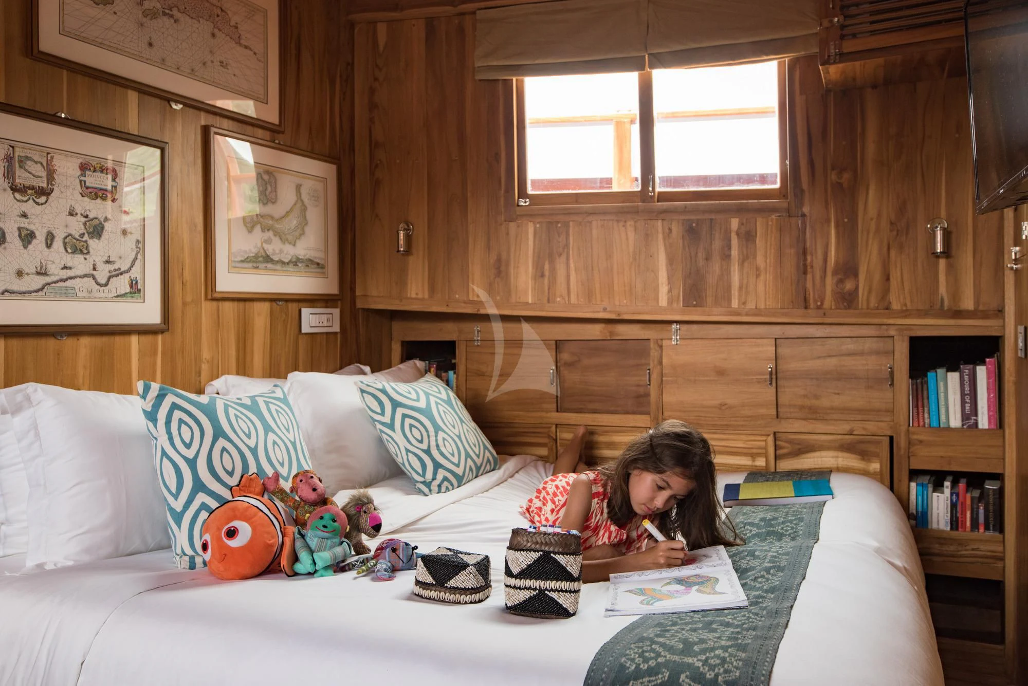 a girl reading a book on a bed aboard SEQUOIA Yacht for Sale