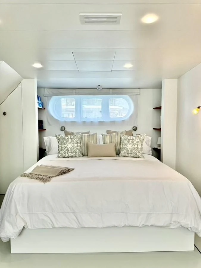 a bed with a white bed spread aboard ABELY Yacht for Sale