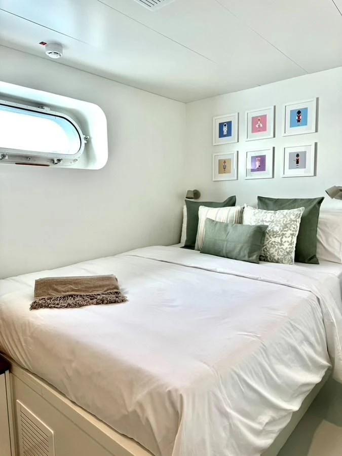 a bed with a white comforter and pillows aboard ABELY Yacht for Sale
