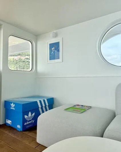 a room with a couch and a table with a mirror aboard ABELY Yacht for Sale