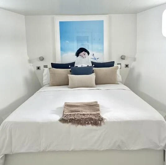 a person sitting on a bed aboard ABELY Yacht for Sale