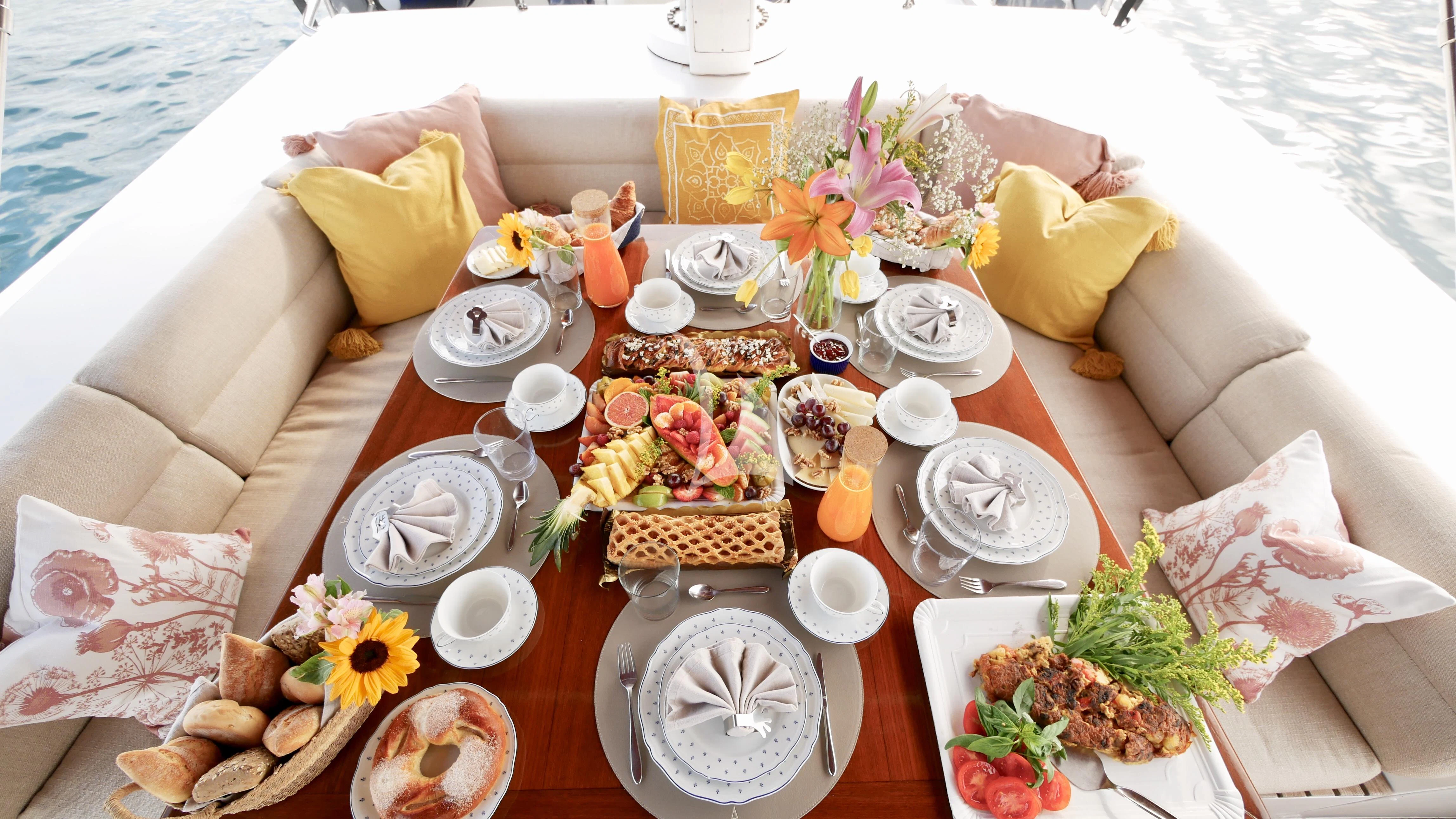 a table with food and drinks on it aboard ABELY Yacht for Sale