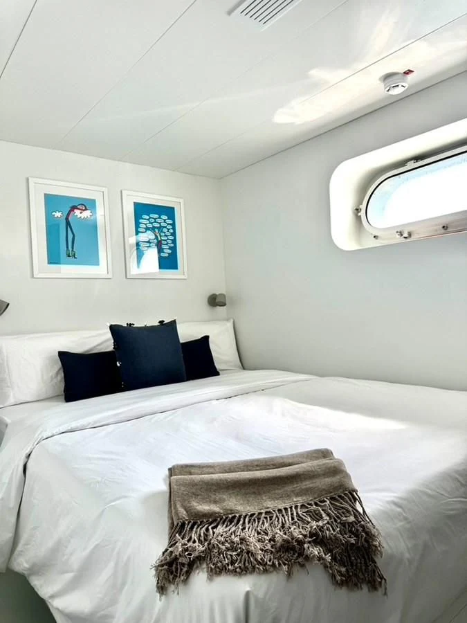a bed with a white comforter aboard ABELY Yacht for Sale