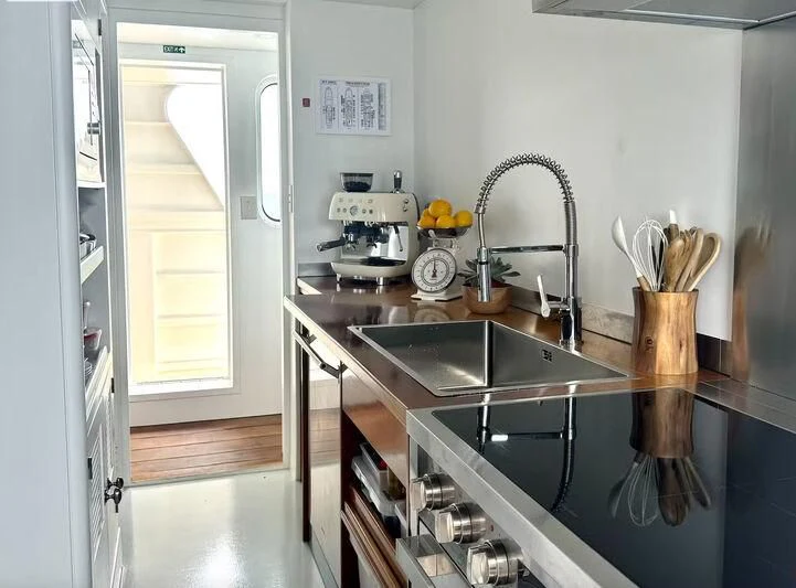 a kitchen with a sink and a refrigerator aboard ABELY Yacht for Sale