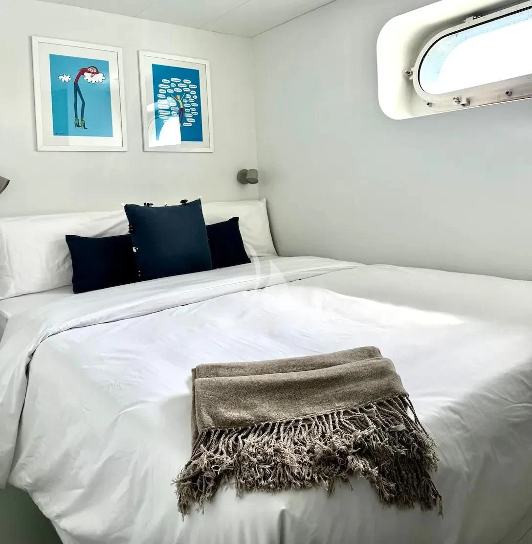 a bed with a white comforter and pillows aboard ABELY Yacht for Sale