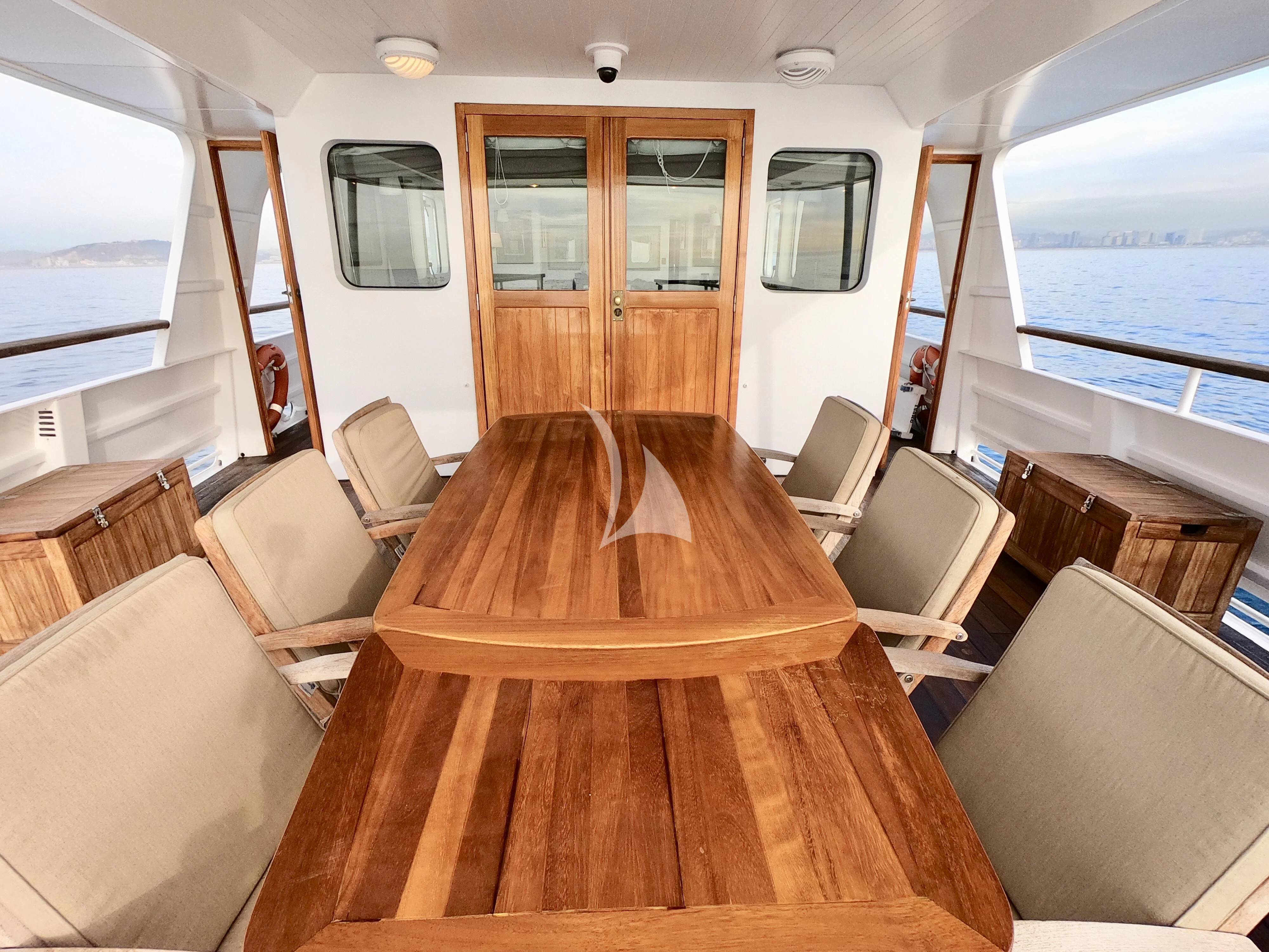 a room with a wood table and chairs aboard ABELY Yacht for Sale
