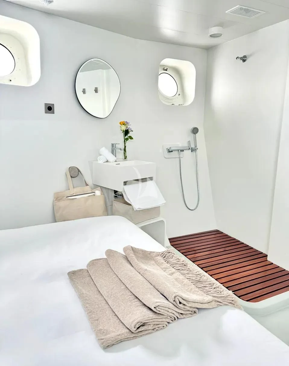 a white bedroom with a bed and a mirror aboard ABELY Yacht for Sale