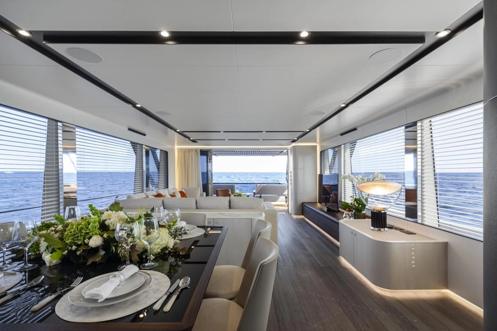 a large room with a table and chairs and a large window aboard SO SO NICE Yacht for Sale