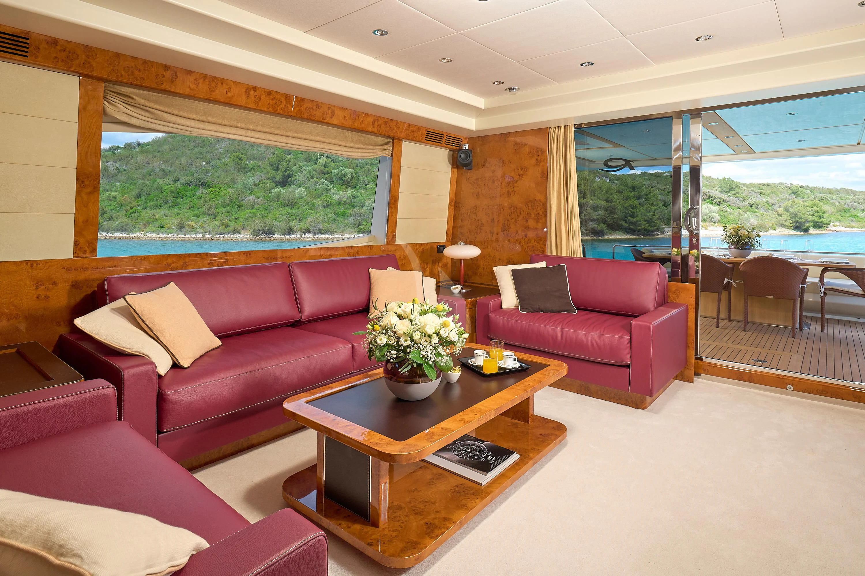 a living room with a table and couches aboard 888 Yacht for Sale