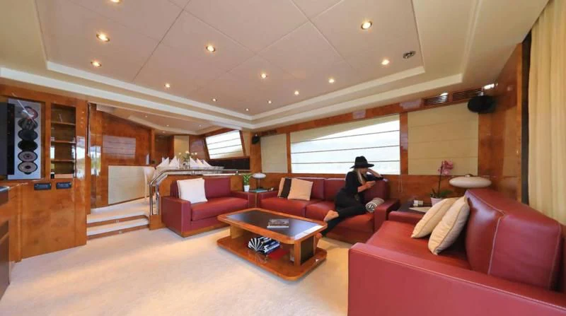 a person sitting on a couch in a living room aboard 888 Yacht for Sale
