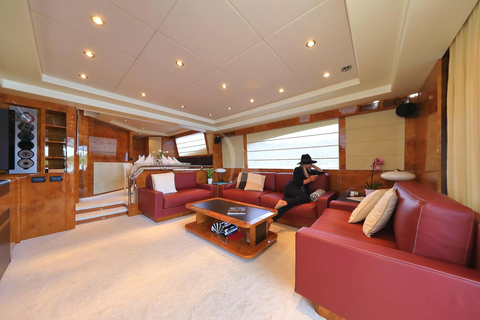 a person sitting on a couch in a living room aboard 888 Yacht for Sale