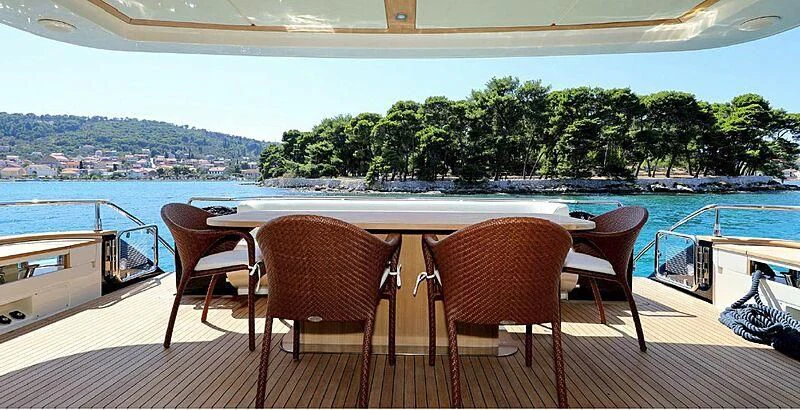 a table and chairs on a deck overlooking a body of water aboard 888 Yacht for Sale