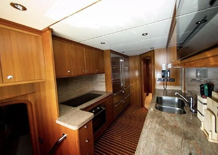 a kitchen with wooden cabinets aboard SOL & SONS Yacht for Sale