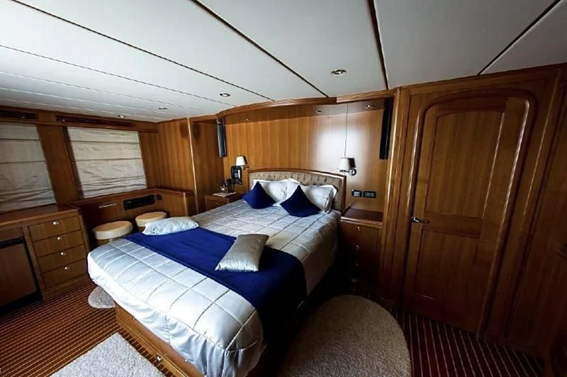 a bedroom with a bed and a wood door aboard SOL & SONS Yacht for Sale
