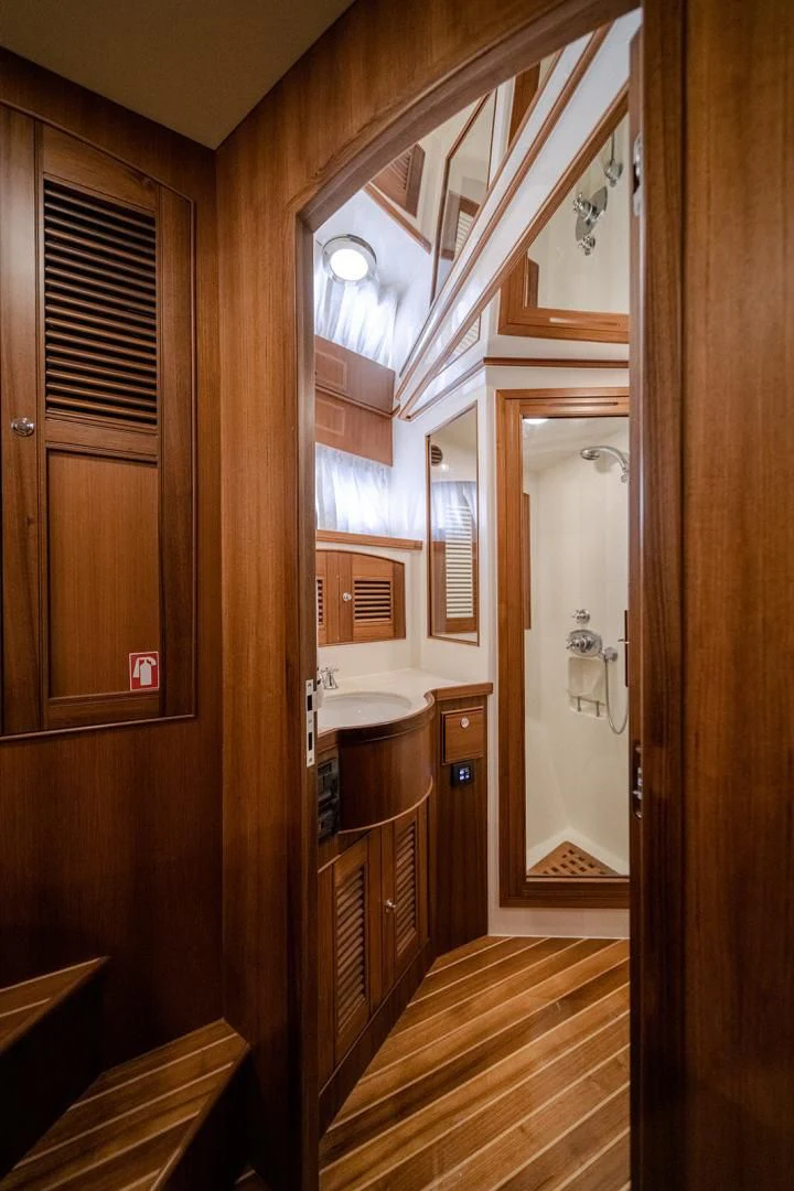 a bathroom with a wood door aboard EASYWAY Yacht for Sale