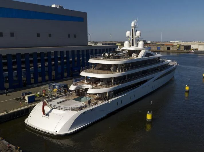 a large ship docked at a pier aboard DEFY Yacht for Sale