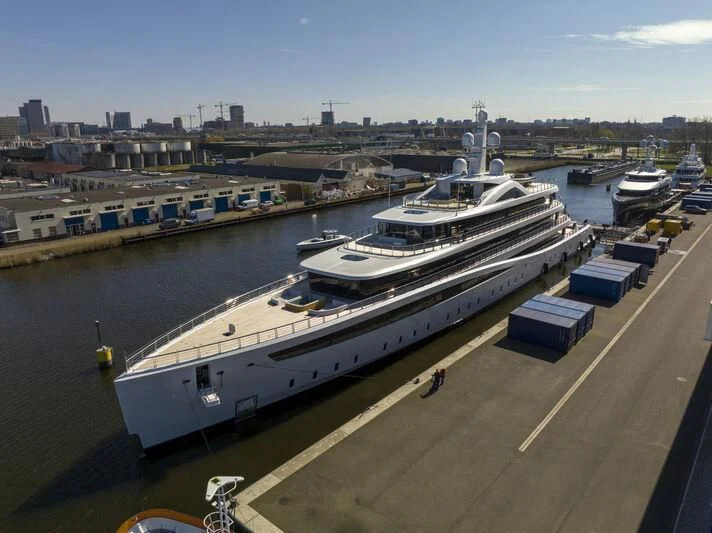 a large ship docked at a port aboard DEFY Yacht for Sale