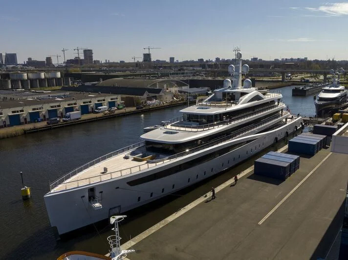 a large ship docked at a port aboard DEFY Yacht for Sale
