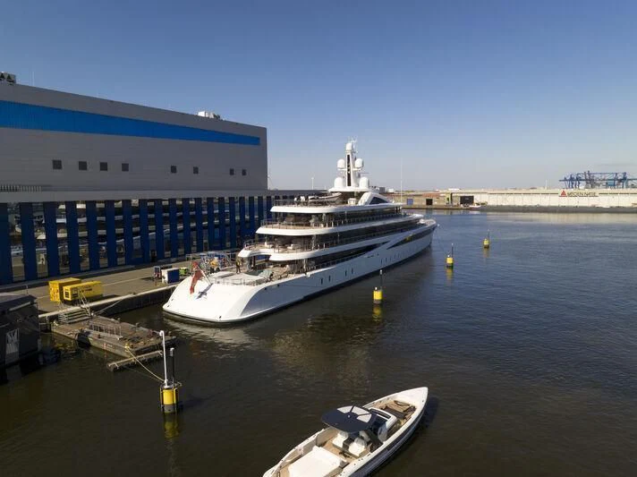 a large cruise ship docked at a port aboard DEFY Yacht for Sale