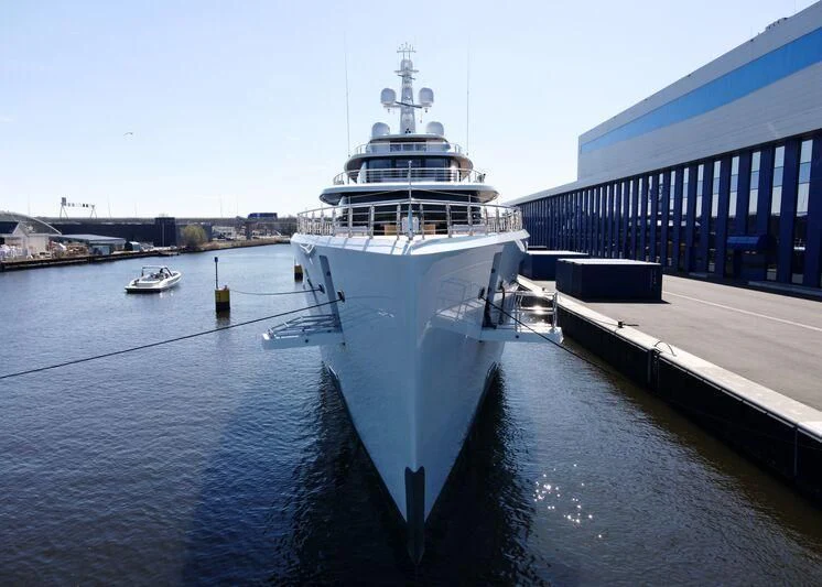 a large ship in a harbor aboard DEFY Yacht for Sale