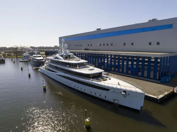 a large ship docked at a pier aboard DEFY Yacht for Sale