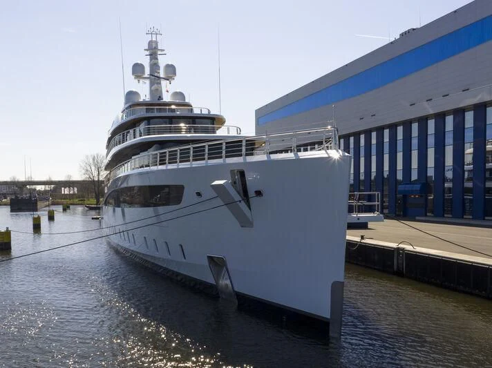 a large ship docked at a pier aboard DEFY Yacht for Sale
