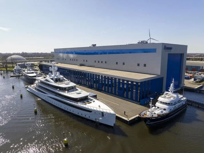 a large ship docked at a pier aboard DEFY Yacht for Sale
