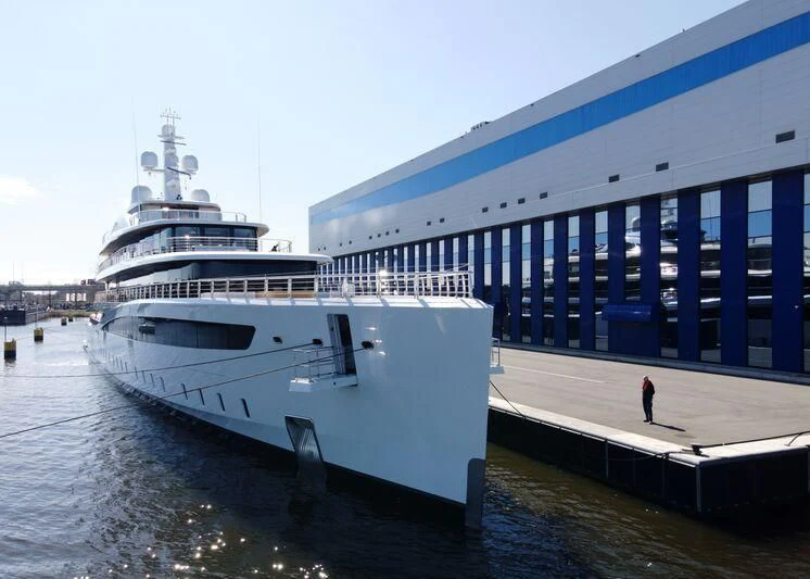 a large white boat docked at a pier aboard DEFY Yacht for Sale
