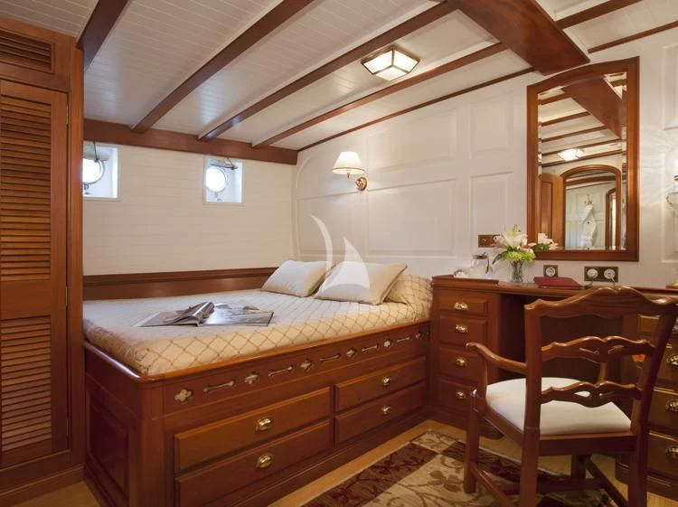 a bedroom with a bed and a desk aboard ELENA OF LONDON Yacht for Sale