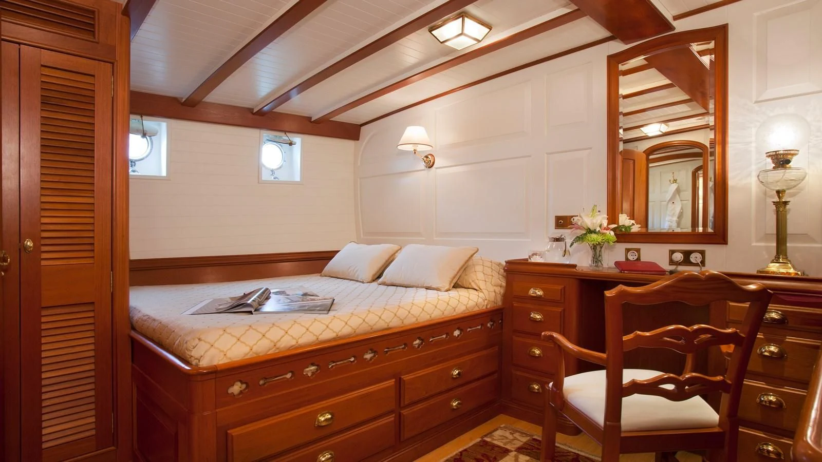 a bedroom with a bed and a desk aboard ELENA OF LONDON Yacht for Sale