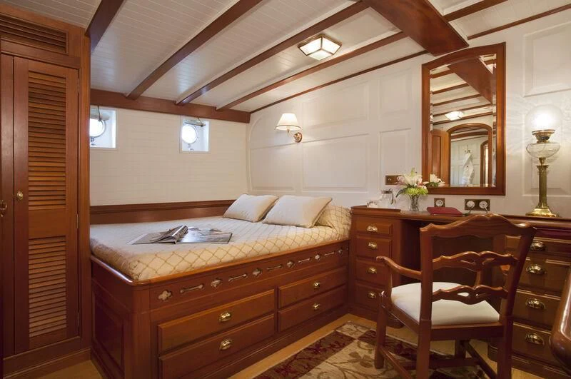 a bedroom with a bed and a chair aboard ELENA OF LONDON Yacht for Sale