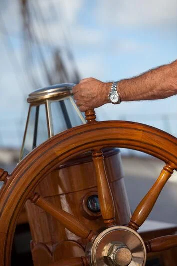 a hand holding a gavel aboard ELENA OF LONDON Yacht for Sale