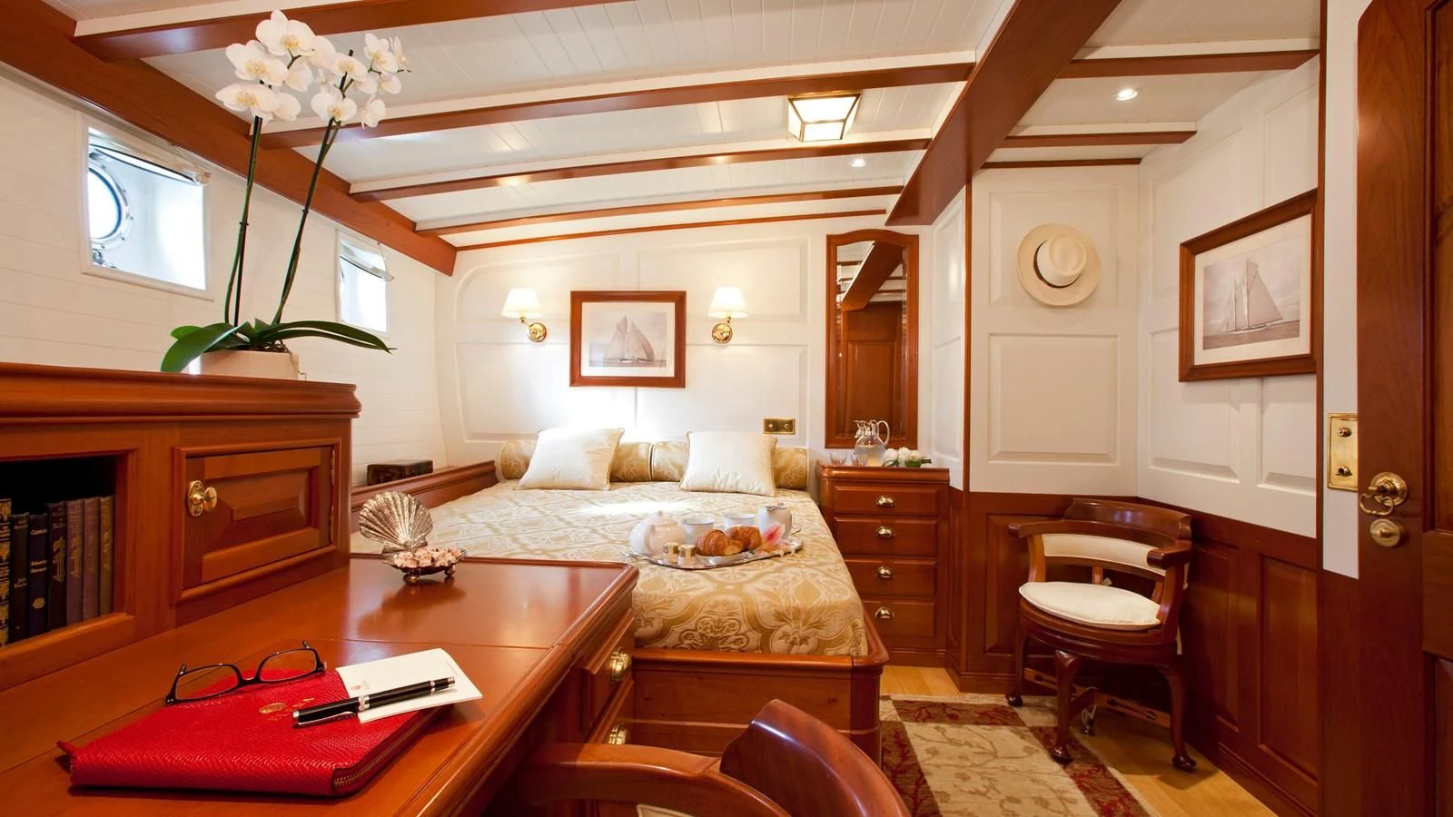 a large bedroom with a bed and a desk aboard ELENA OF LONDON Yacht for Sale