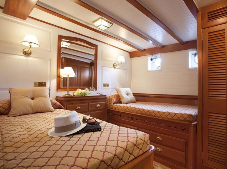 a bedroom with a bed and a desk aboard ELENA OF LONDON Yacht for Sale