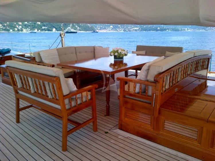 a deck with chairs and a table on it aboard ELENA OF LONDON Yacht for Sale
