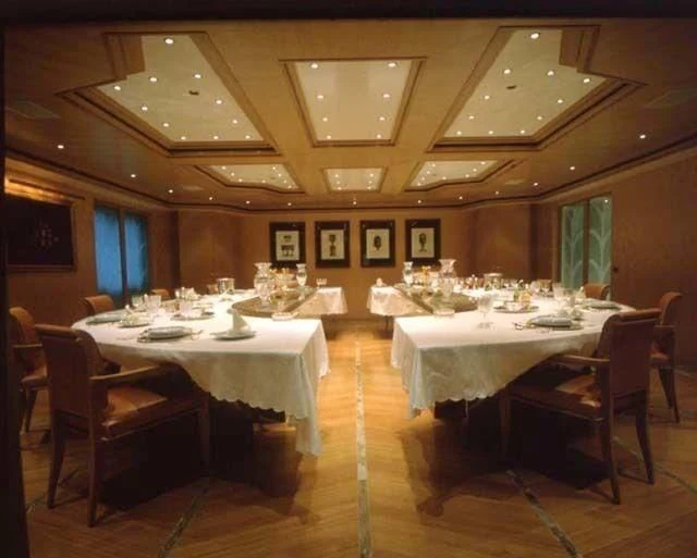 a room with tables and chairs aboard CONSTELLATION Yacht for Sale