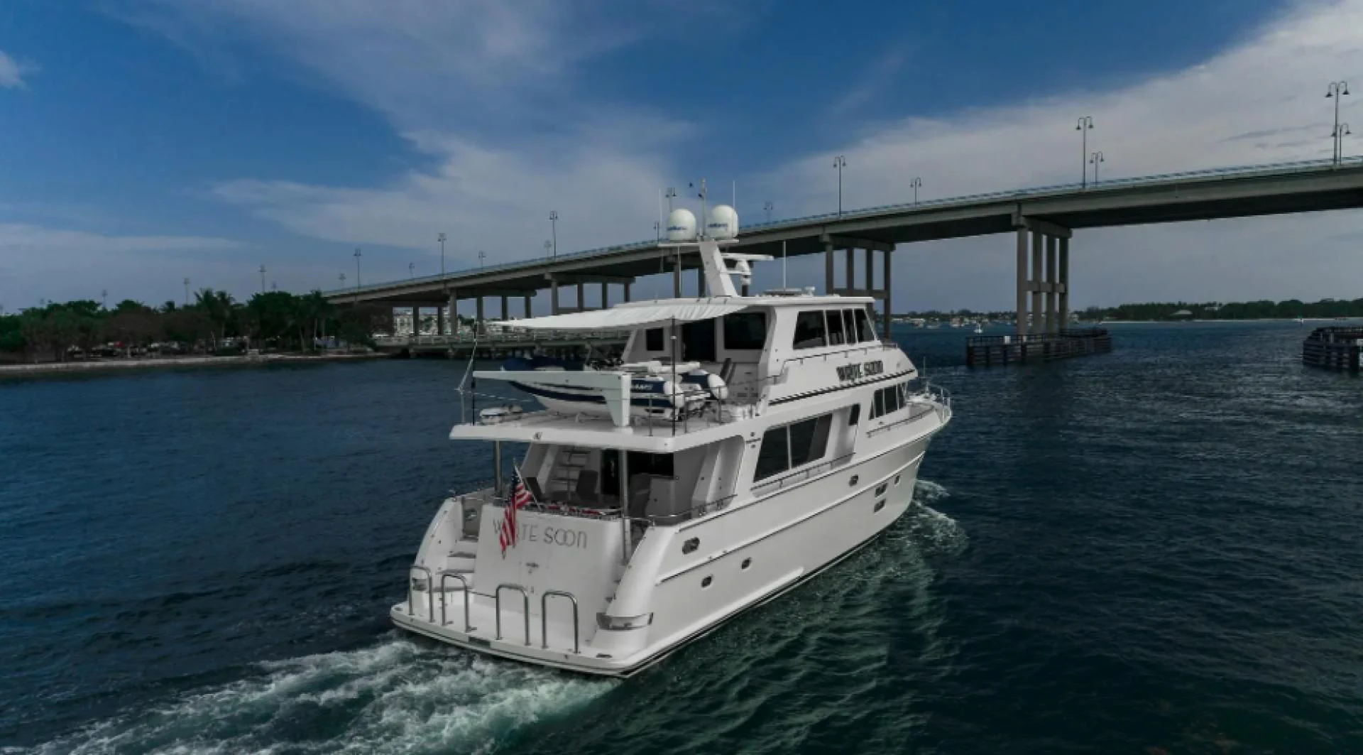 a boat sailing under a bridge aboard WRITE SOON Yacht for Sale