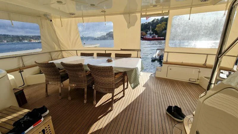a room with a table chairs and a large window aboard ABK Yacht for Sale