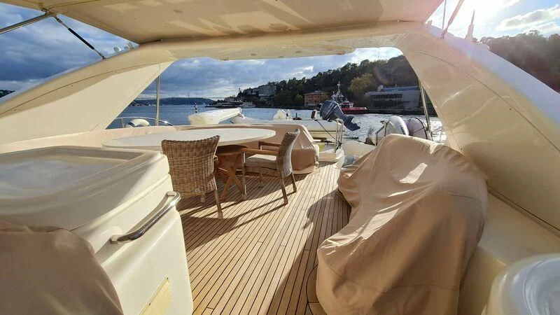 a room with a table chairs and a body of water in the background aboard ABK Yacht for Sale