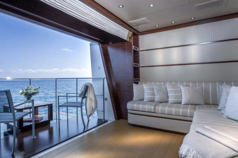 a room with a couch and a table and a view of the ocean aboard ATLAS Yacht for Sale