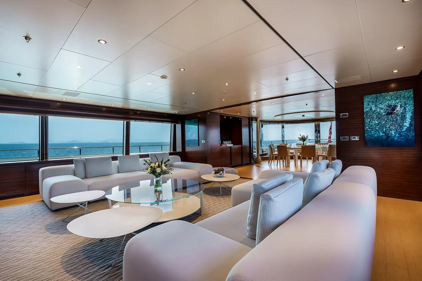 a room with white chairs and a table with a vase of flowers on it aboard ATLAS Yacht for Sale