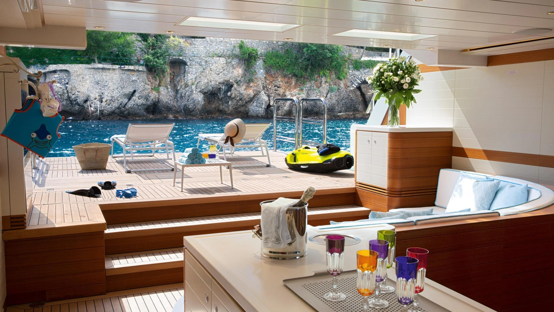 a table with drinks and a large window with a view of the water aboard LATONA Yacht for Sale